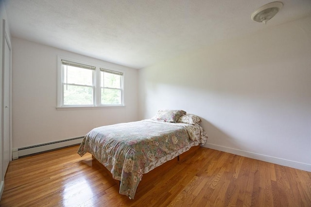 286 Mountain St, Sharon, MA 02067 - bedroom with a baseboard heating unit and wood finished floors