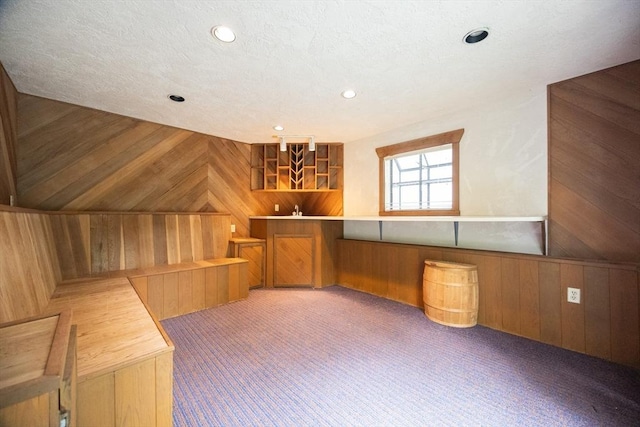 286 Mountain St, Sharon, MA 02067 - additional living space with wood walls, carpet flooring, recessed lighting, and bar