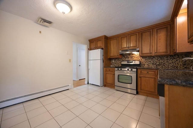 286 Mountain St, Sharon, MA 02067 - kitchen featuring stainless steel range with gas stovetop, freestanding refrigerator, under cabinet range hood, and brown cabinetry