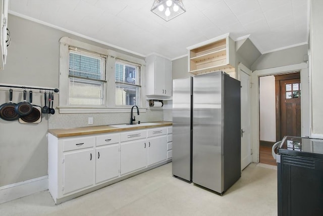 kitchen featuring open shelves, freestanding refrigerator, white cabinetry, a sink, and black / electric stove