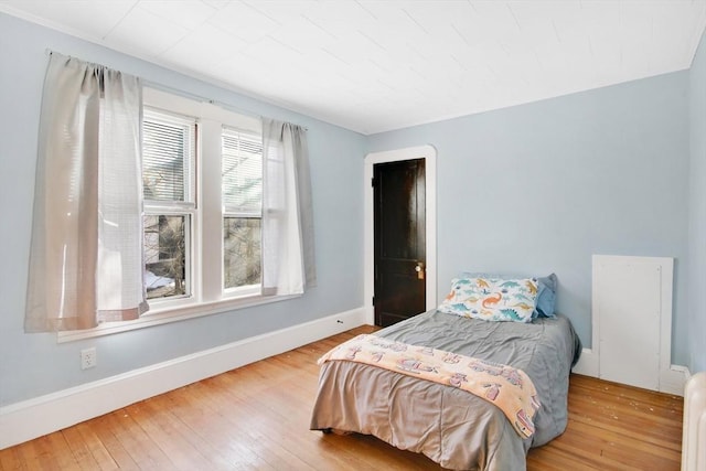 bedroom with hardwood / wood-style flooring and baseboards