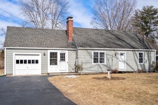 view of front of house featuring driveway, a chimney, a shingled roof, a front lawn, and a garage