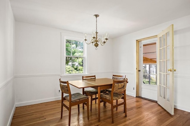 dining room featuring an inviting chandelier, baseboards, french doors, and wood finished floors