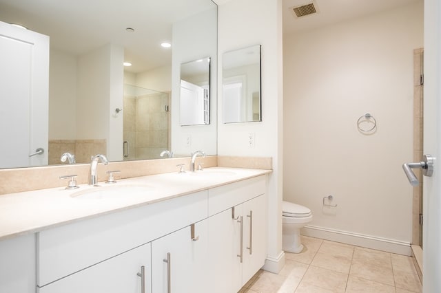 bathroom featuring tile patterned flooring, vanity, a shower with door, and toilet