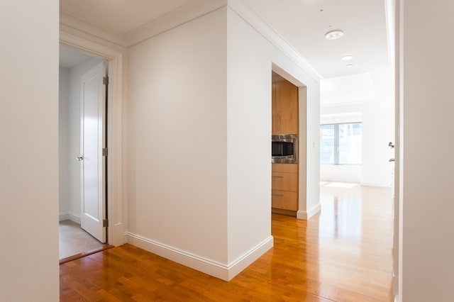 hallway with hardwood / wood-style flooring and ornamental molding