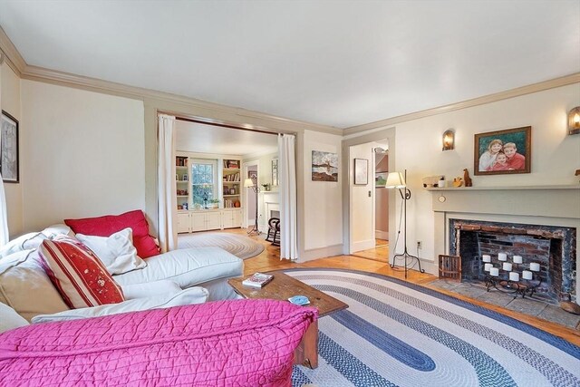 34 Fletcher Ln, Littleton, MA 01460 - living area featuring light wood-type flooring, crown molding, and a fireplace with flush hearth
