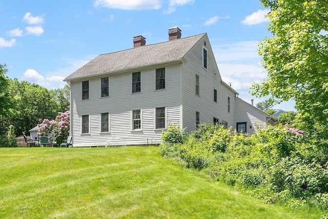 34 Fletcher Ln, Littleton, MA 01460 - rear view of house featuring a chimney and a lawn
