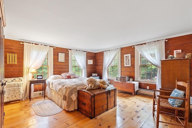 34 Fletcher Ln, Littleton, MA 01460 - bedroom featuring multiple windows, light wood-style floors, a baseboard radiator, and wooden walls