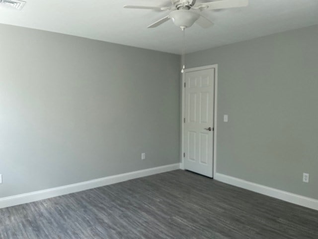 empty room with ceiling fan and dark hardwood / wood-style floors