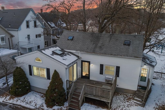 snow covered house featuring a deck