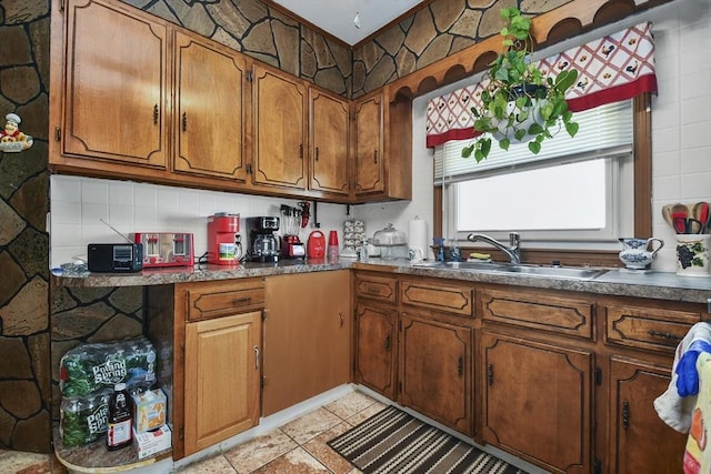 kitchen featuring dark countertops, brown cabinets, and a sink