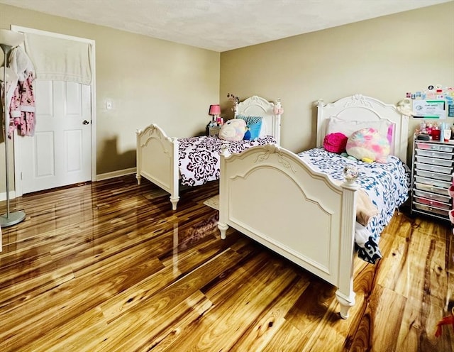 bedroom featuring baseboards and wood finished floors