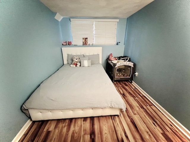 bedroom featuring baseboards and wood finished floors