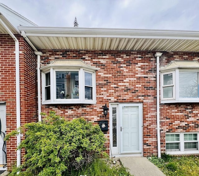 view of exterior entry with brick siding