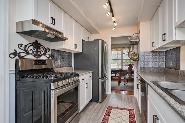 kitchen with white cabinetry, decorative backsplash, stainless steel appliances, and light hardwood / wood-style flooring