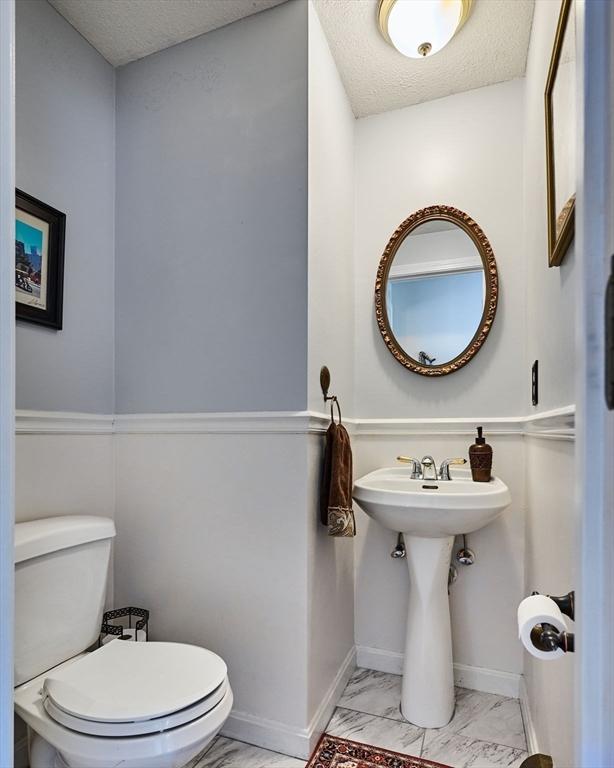 bathroom with toilet and a textured ceiling