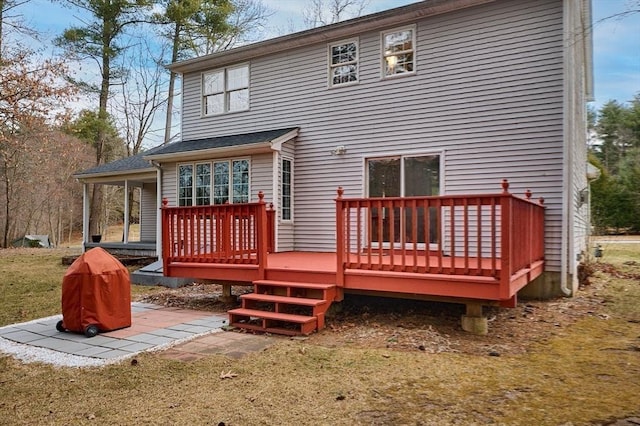 back of house with a wooden deck and a yard