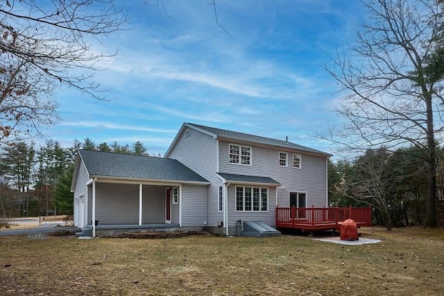 rear view of house featuring a wooden deck and a yard