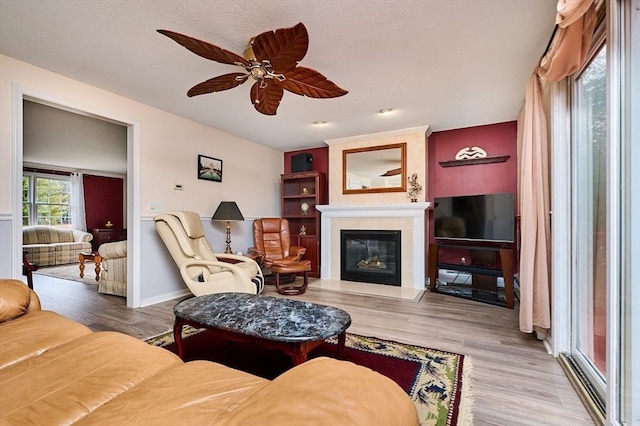 living room with hardwood / wood-style floors, a textured ceiling, and ceiling fan