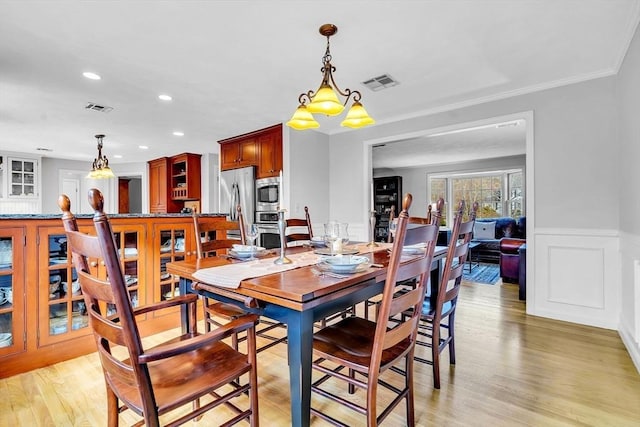 dining room featuring light wood-style floors, recessed lighting, a wainscoted wall, and visible vents