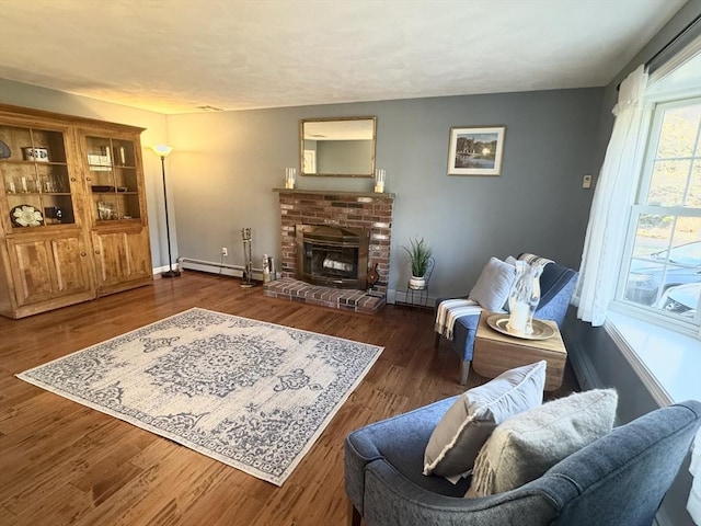 living room with baseboards, a fireplace, baseboard heating, and wood finished floors