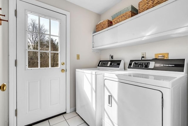 washroom with light tile patterned floors, laundry area, and washer and dryer