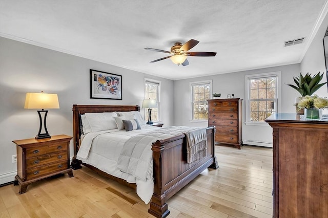 bedroom featuring crown molding, visible vents, a baseboard heating unit, ceiling fan, and light wood-type flooring