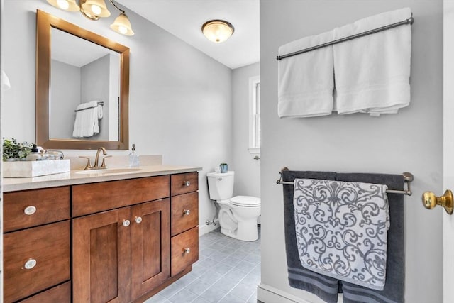 bathroom with tile patterned flooring, baseboards, vanity, and toilet