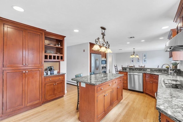 kitchen featuring light wood-style flooring, visible vents, stainless steel appliances, and dark stone counters