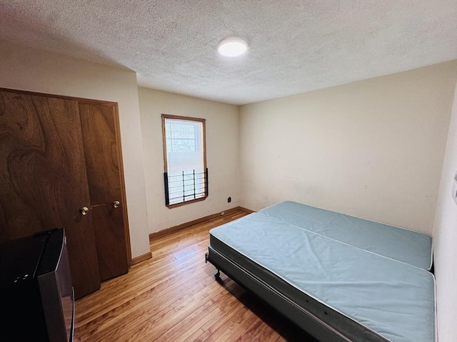 27 Shelby St, Worcester, MA 01605 - bedroom featuring light wood-style flooring, a textured ceiling, and a closet