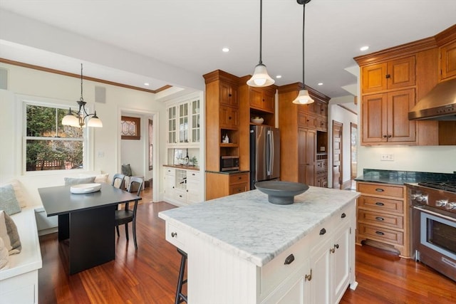 kitchen with a kitchen island, recessed lighting, appliances with stainless steel finishes, crown molding, and dark wood-style flooring