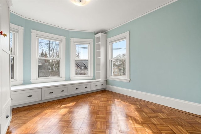 spare room with baseboards and crown molding