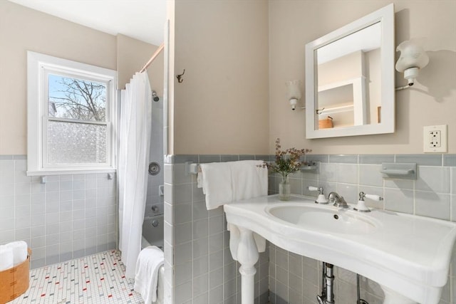 bathroom featuring tile patterned floors, a wainscoted wall, tile walls, and shower / bathtub combination with curtain