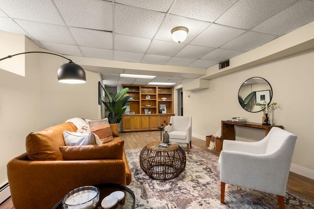 living room with visible vents, baseboards, baseboard heating, and light wood-style flooring