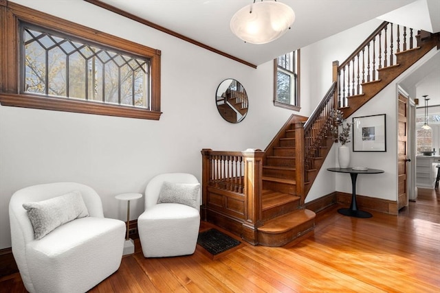 staircase with hardwood / wood-style floors, crown molding, and baseboards