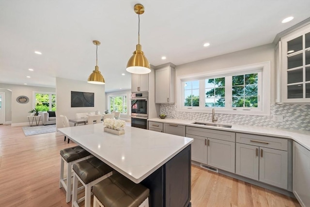 43 Lake Ave, Sharon, MA 02067 - kitchen featuring stainless steel double oven, gray cabinets, decorative backsplash, plenty of natural light, and recessed lighting