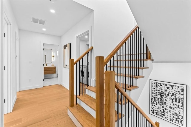 staircase with baseboards, visible vents, wood finished floors, and recessed lighting