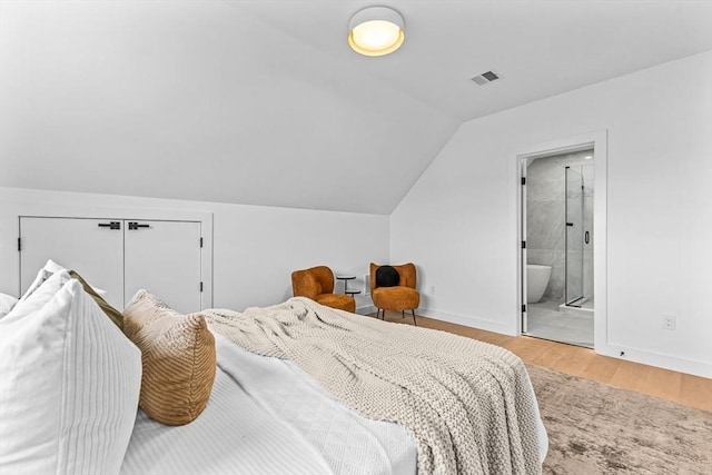 bedroom featuring light wood-type flooring, baseboards, visible vents, and vaulted ceiling