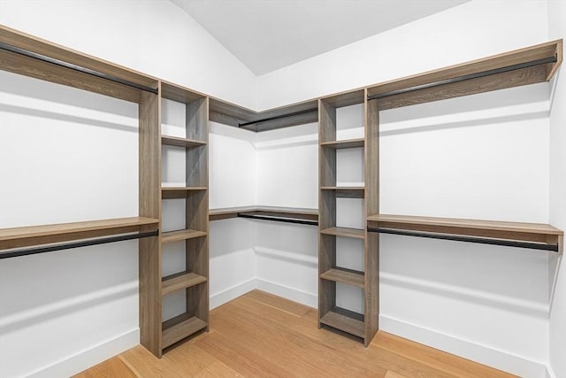 walk in closet with lofted ceiling and light wood-style flooring