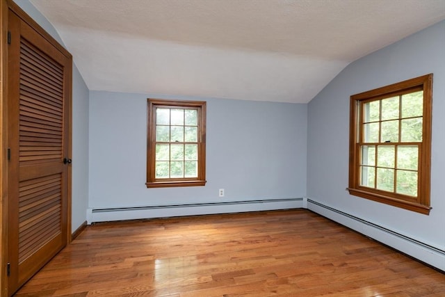 10 Whipple Rd, Hamilton, MA 01982 - unfurnished bedroom with vaulted ceiling, a baseboard heating unit, light wood-style floors, a closet, and multiple windows