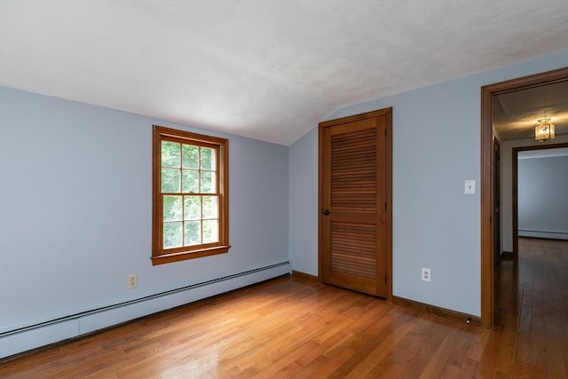 10 Whipple Rd, Hamilton, MA 01982 - unfurnished bedroom featuring baseboard heating, a closet, a baseboard heating unit, lofted ceiling, and light wood-type flooring