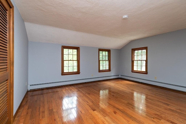 10 Whipple Rd, Hamilton, MA 01982 - empty room featuring lofted ceiling, hardwood / wood-style flooring, a smoke detector, a textured ceiling, and a baseboard radiator