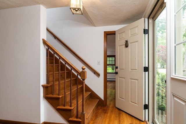 10 Whipple Rd, Hamilton, MA 01982 - entryway featuring light wood-type flooring, baseboard heating, a textured ceiling, stairs, and baseboards