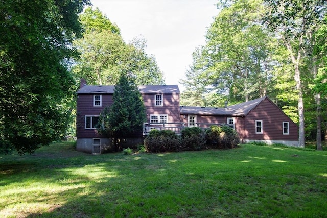 10 Whipple Rd, Hamilton, MA 01982 - back of property featuring a yard, a wooden deck, a chimney, and view of wooded area