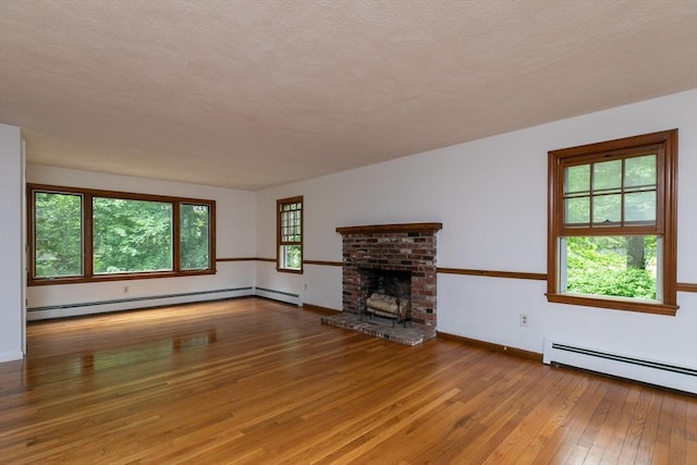 10 Whipple Rd, Hamilton, MA 01982 - unfurnished living room with hardwood / wood-style flooring, baseboard heating, a brick fireplace, and a textured ceiling