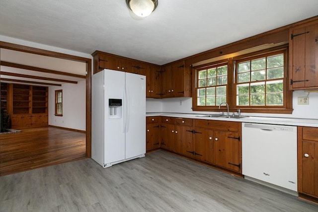 10 Whipple Rd, Hamilton, MA 01982 - kitchen featuring white appliances, a sink, light wood-style flooring, light countertops, and brown cabinetry
