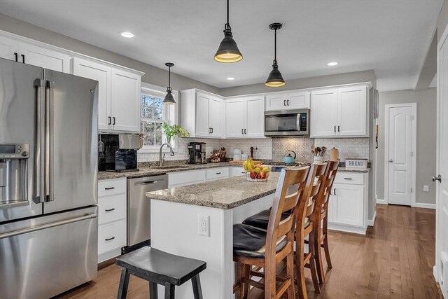 261 Bean Porridge Hill Rd, Westminster, MA 01473 - kitchen featuring backsplash, a sink, a kitchen bar, stainless steel appliances, and white cabinets