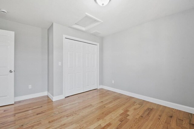 119 Tripp St, Fall River, MA 02724 - unfurnished bedroom featuring attic access, light wood finished floors, and a closet