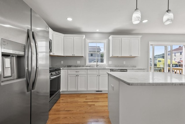119 Tripp St, Fall River, MA 02724 - kitchen featuring stainless steel appliances, light wood-style flooring, white cabinetry, healthy amount of natural light, and recessed lighting