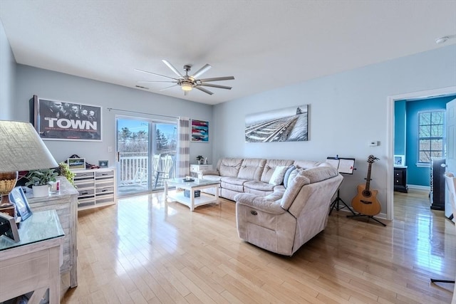 living room with light wood-style floors, baseboards, and ceiling fan